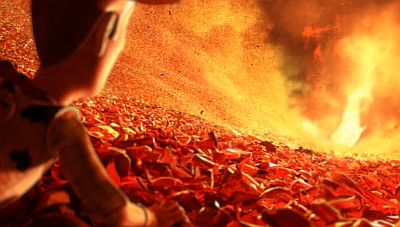 Screen capture from Toy Story 3 scene where tho toys are found in the dumpster and are trying to escape from the furnace that is burning all the garbage. Woody is looking towards the fire and how it is destroying the garbage ahead of him.